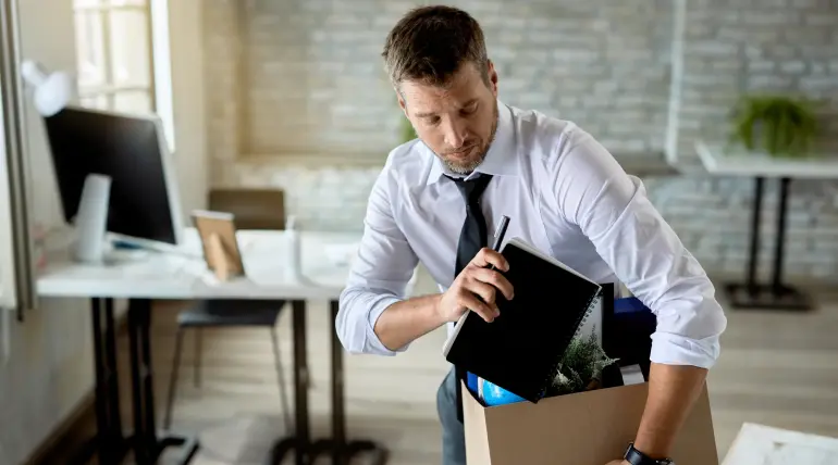 Dipendente mette le sue cose in una scatola dopo aver lasciato il lavoro