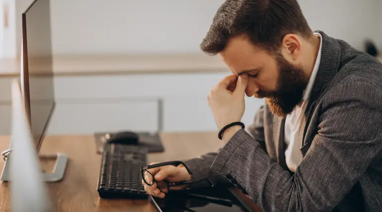 Uomo preoccupato alla scrivania dopo il rifiuto di un prestito
