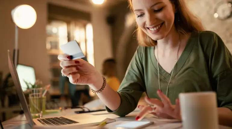 Donna sorridente controlla sullo smartphone l’accredito del prestito